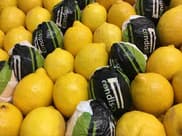 Lemons, some wrapped in branded paper, in a display box