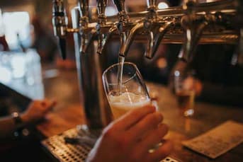 Pint of lager being poured from a pub beer tap