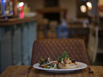 Plated pub meal on a wooden table in a cosy dining room