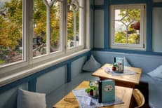 Cosy café corner with window seating, wooden tables and menus