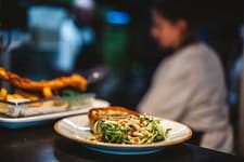 Plated pub meal of fish with salad, served at a table