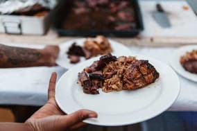 Plate of pulled pork and barbecued meat being served at a street food stall