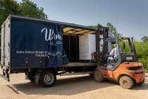 Forklift loading a delivery lorry at a farm