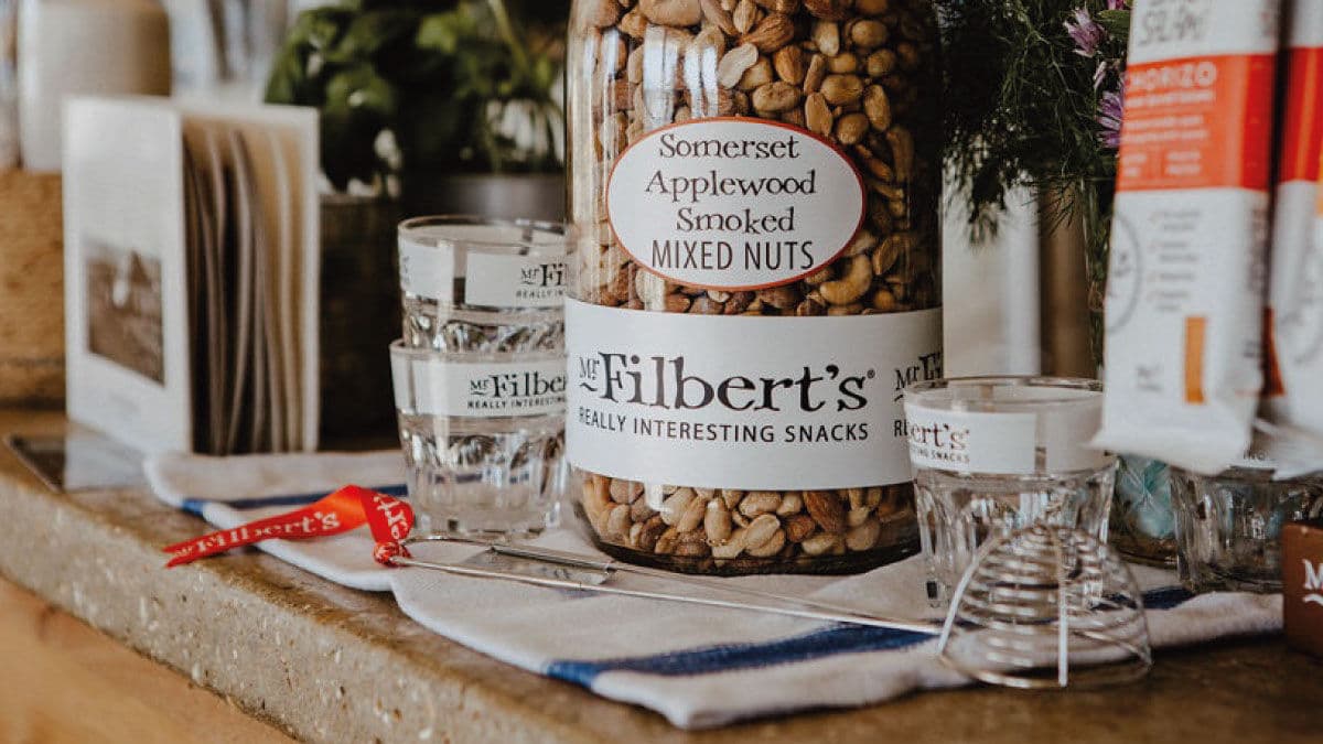 Jar of Mr Filbert's Somerset applewood smoked mixed nuts on a bar counter