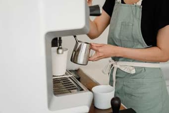 Barista steaming milk at an espresso machine