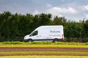 White WestCountry delivery van parked beside a farm field