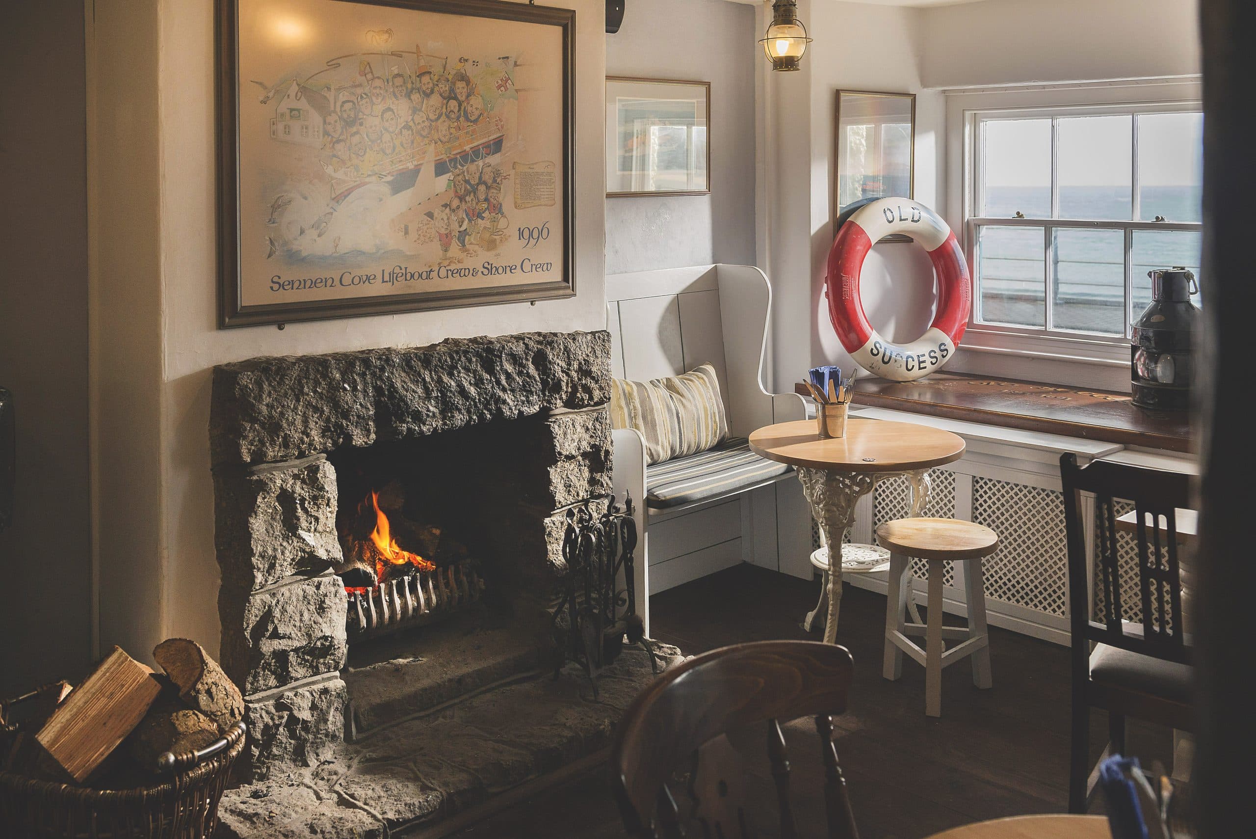 Pub snug with an open log fire, lifebuoy and sea-view window