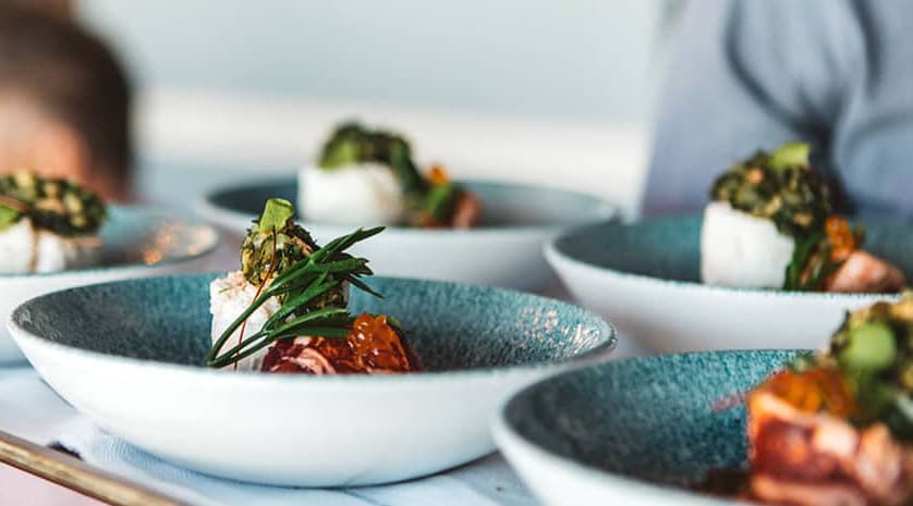 Plated starters in speckled blue bowls ready to serve