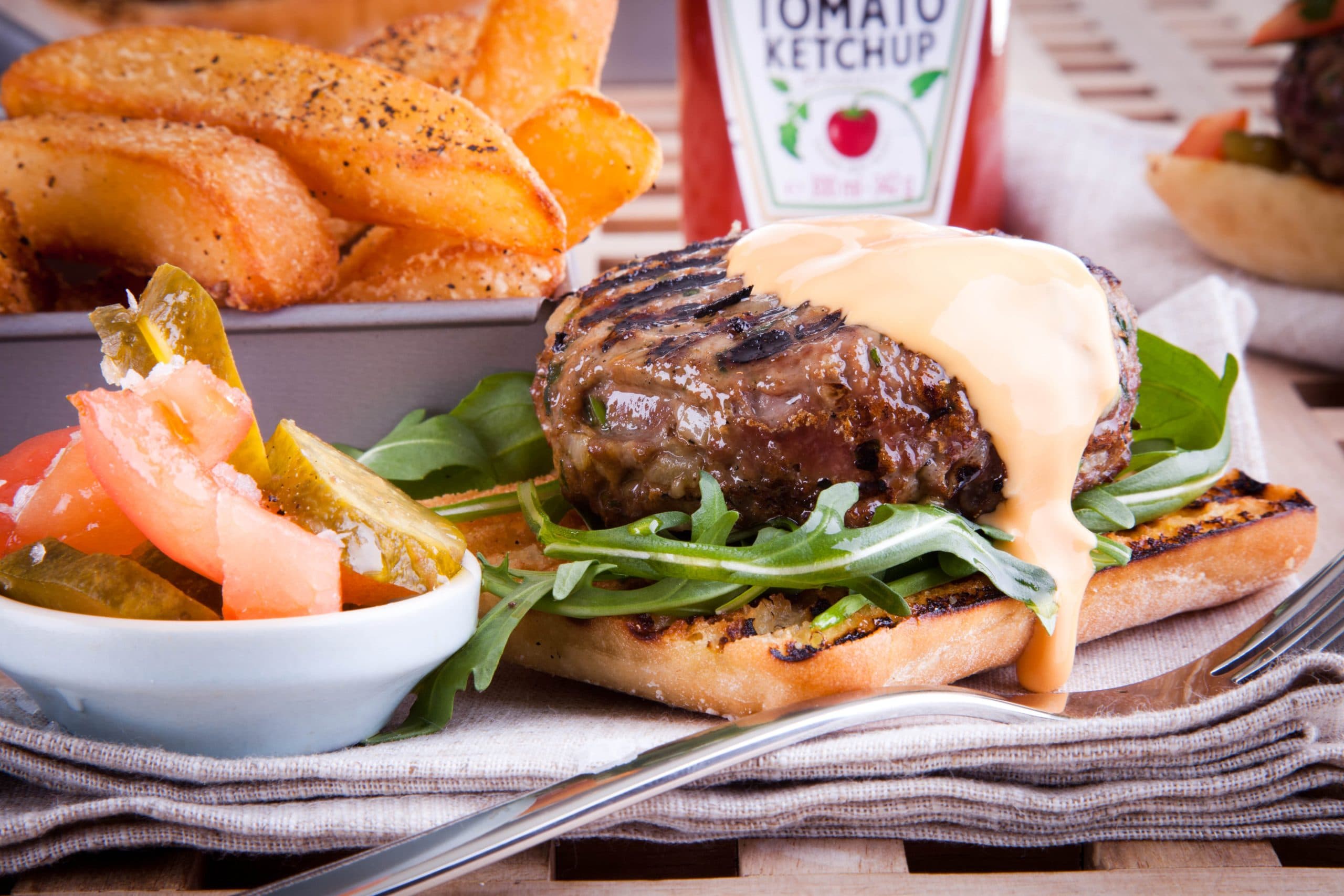 Burger with cheese sauce, chips and ketchup
