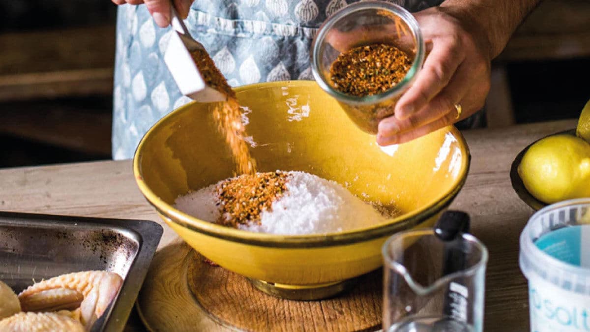 Cook mixing spices into sea salt in a yellow bowl