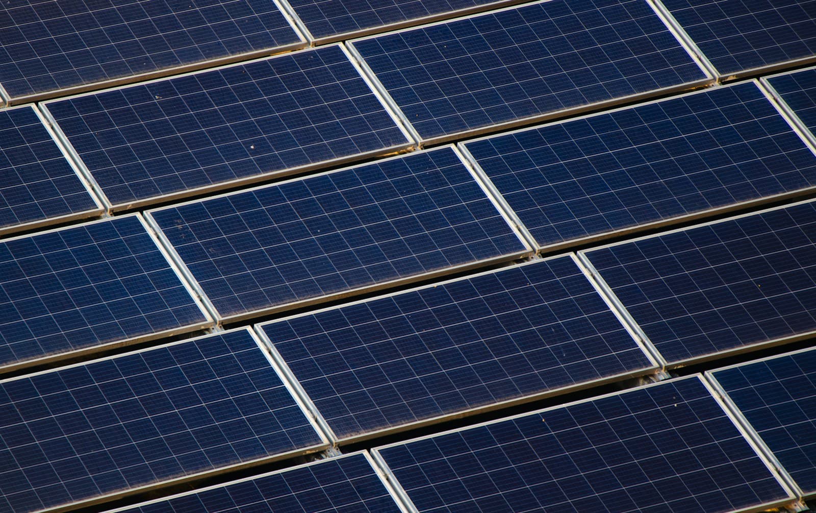 a large amount of solar panels on the roof of a building